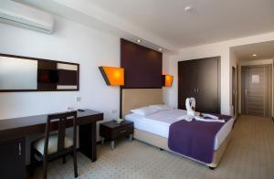 een hotelkamer met een bed en een bureau bij SUPREME BEACH İÇMELER Adults Only in Marmaris