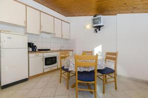 cocina con mesa y sillas y TV en Apartments Nada, en Grebaštica