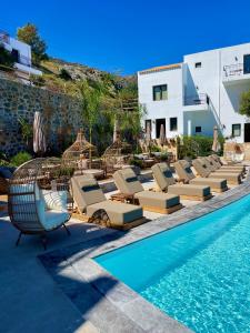 a row of lounge chairs next to a swimming pool at Creta Blue Boutique Hotel in Hersonissos