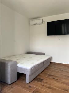 a bedroom with a bed and a flat screen tv at Guest House Ivan in Donji Zemunik