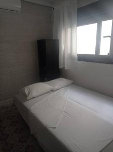 Cette chambre blanche dispose d'un lit et d'une fenêtre. dans l'établissement Centro de Málaga - Calle Zanca, à Malaga