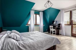 niebieska sypialnia z łóżkiem i biurkiem w obiekcie Apartamenty Wierchówka w Bukowinie Tatrzańskiej