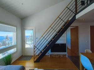 een trap in een woonkamer met een groot raam bij The Peak House in Syöte