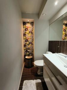 W łazience znajduje się umywalka, toaleta i lustro. w obiekcie The Peak House w mieście Syöte