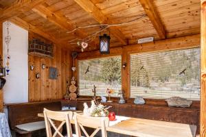 uma sala de jantar com uma mesa e duas janelas em Adlerhorst Zaunkoenig em Santa Valpurga