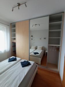 a bedroom with two beds and a mirror at Budapest Airport Apartment in Budapest
