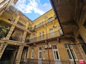 un edificio amarillo con balcones en un lateral en Bercsényi apartments - close to the Gellért Thermal Bath, en Budapest