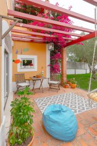 un patio con pérgola, mesa y sillas en Casa da Foz - Charming House, en Foz do Arelho