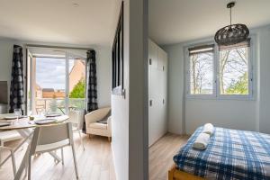 1 dormitorio con 1 cama y comedor con mesa en "Le Marmuzot" - Confort - Calme - Parking Free, en Dijon