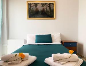 a bedroom with a green bed with two towels at Vintage Manor in Anavissos