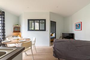een keuken en een woonkamer met een tafel en een wastafel bij "Le Marmuzot" - Confort - Calme - Parking Free in Dijon