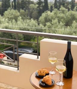 a table with two glasses of white wine and bread at Vintage Manor in Anavissos