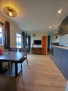 a living room with a table and a kitchen at Chalet Oppe Hook in Kessel