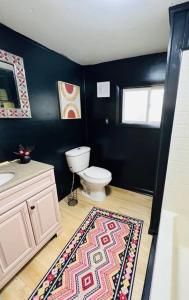 a bathroom with a toilet and a sink and a rug at Black Ridgetop at NRG National Park in Lansing