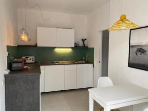 a kitchen with white cabinets and a table in it at Apartment Olive in Medulin