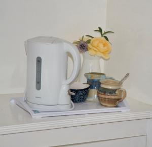 a counter with a coffee maker and vases on it at Cissbury in Midhurst