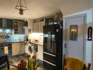 a kitchen with a black refrigerator and a table at Cissbury in Midhurst