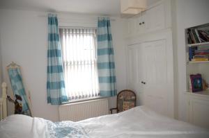 a bedroom with a bed and two windows at Cissbury in Midhurst