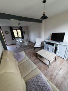 ein Wohnzimmer mit einem Sofa und einem Tisch in der Unterkunft La framboisette in Le Vaudreuil