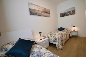 a bedroom with two beds and a table with two lamps at Blu Homes Apartments EfStyle Hotel in Lido di Jesolo +28 photos