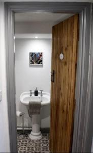 a bathroom with a sink and a toilet and a door at Brackendale in Bala