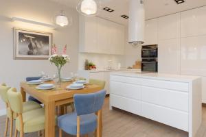 a kitchen with a wooden table and blue chairs at Three-Bedroom Family House with Garden Warsaw Nowa Wieś by Noclegi Renters in Warszawa +32 photos