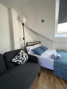 a bedroom with a bed and a couch and a window at 4 Wharncliffe Drive in Hanwell