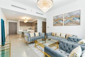 a living room with blue couches and a table at Vacay Lettings - Getaway home Dubai Creek Harbour in Dubai