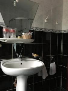 bagno con lavandino bianco e specchio di Ancora a Predeal