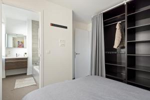 a bedroom with a bed and a bathroom with a mirror at Ernest 33 in Antwerp