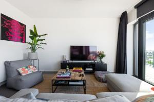 a living room with a couch and a tv at Ernest 33 in Antwerp