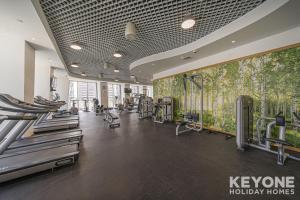 a gym with a bunch of treadmills and machines at Lavish One Bedroom with Amazing Sun Deck & Pool in Dubai