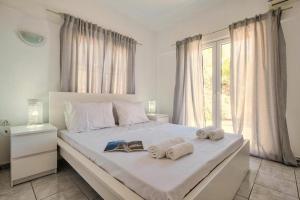 a bedroom with a large bed with towels on it at Villa Nikolitsa with private beach in Megara