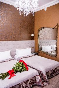 ein Schlafzimmer mit 2 Betten mit Blumenarrangement darauf in der Unterkunft Boutique Spa Casino Hotel Lybid Plaza in Chmelnyzkyj