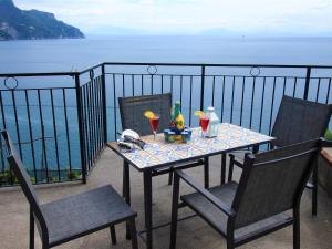 stół i krzesła na balkonie z widokiem na ocean w obiekcie Casa Skyline a Ravello w mieście Atrani
