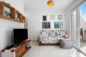 ein Wohnzimmer mit Couch und Flachbildfernseher in der Unterkunft Beach Apartment Corralejo Escape in Corralejo