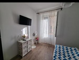 a bedroom with a bed and a dresser and a window at Stella Apartment Šibenik Charm&history united in Šibenik