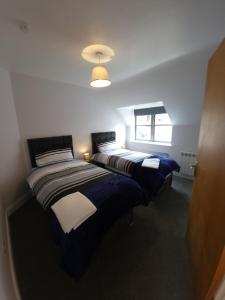 two beds in a room with a window at Crew's Apartment in Dungarvan