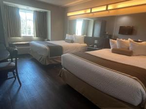 um quarto de hotel com duas camas e uma secretária em Microtel Inn & Suites by Wyndham Pearl River/Slidell em Pearl River