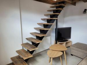uma escada em espiral num quarto com uma mesa e uma televisão em Gîte La Toue em Saint-Dyé-sur-Loire