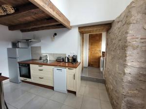 uma cozinha com electrodomésticos brancos e uma parede de pedra em Gîte La Toue em Saint-Dyé-sur-Loire