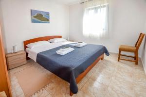 a bedroom with a bed and a chair and a window at House Kastel in Tkon