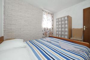 a bedroom with a bed and a brick wall at House Lovre in Tkon