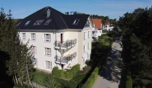 an aerial view of a large white building with a black roof at Strandhaus Aurell in Heringsdorf