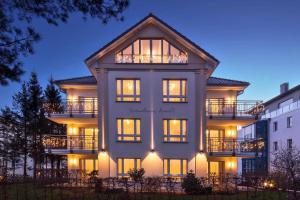 un gran edificio blanco con luces encendidas en Strandhaus Aurell, en Heringsdorf