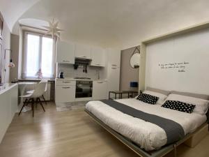 a bedroom with a large bed and a kitchen at Grigio Perla in Cuneo