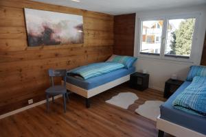 una camera da letto con pareti in legno, un letto e una finestra di Rosenheim a Saas-Grund