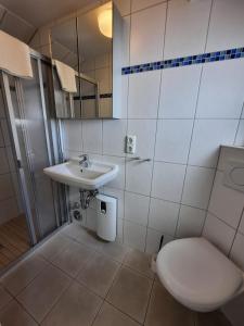 La salle de bains est pourvue de toilettes et d'un lavabo. dans l'établissement Landhaus Bode, à Travemünde