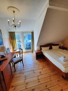 a bedroom with a bed and a desk and a desk at Landhaus Bode in Travemünde