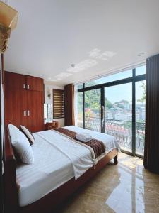 a bedroom with a large bed and a large window at CHÉRIE HOMEHOTEL in Ha Long